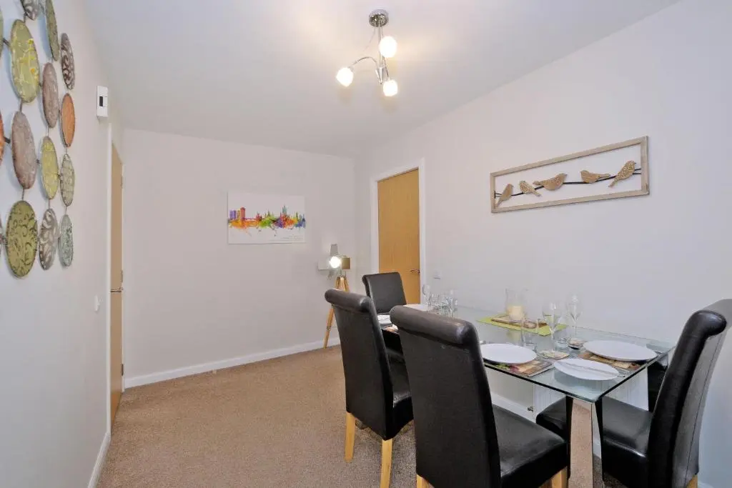 a dining room with a table and black chairs at Caledonia Netherhills Apartment in Aberdeen
