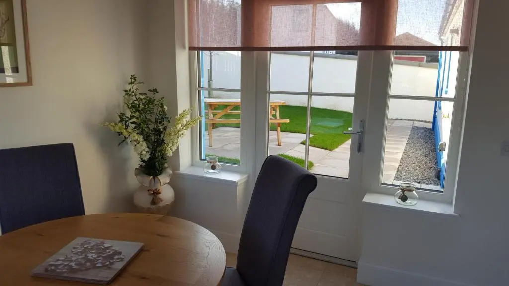 a dining room with a table and a window at Olavat Cottage detached property with parking in Inverness