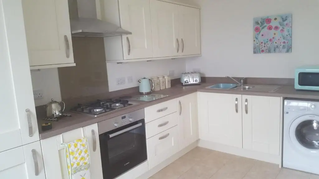a kitchen with white cabinets and a stove top oven at Olavat Cottage detached property with parking in Inverness