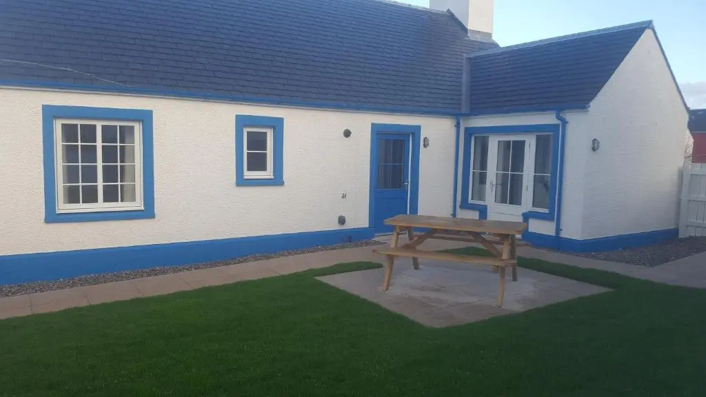 a picnic table in front of a house at Olavat Cottage detached property with parking in Inverness