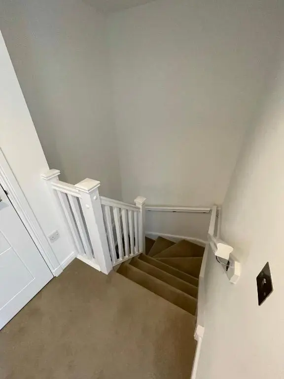 a staircase with white railings and a stair case at Foxglove Apartment in Inverness