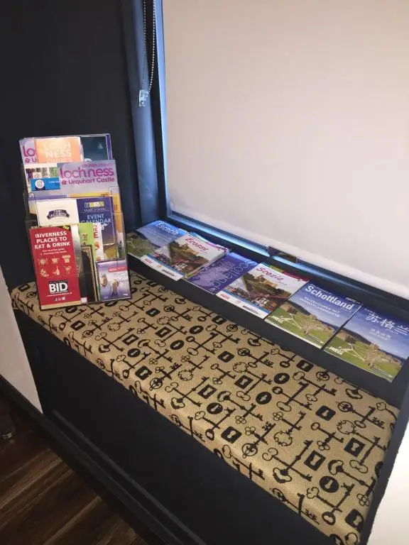 a shelf with books and other items on it at Caledonian Canal Studio in Inverness