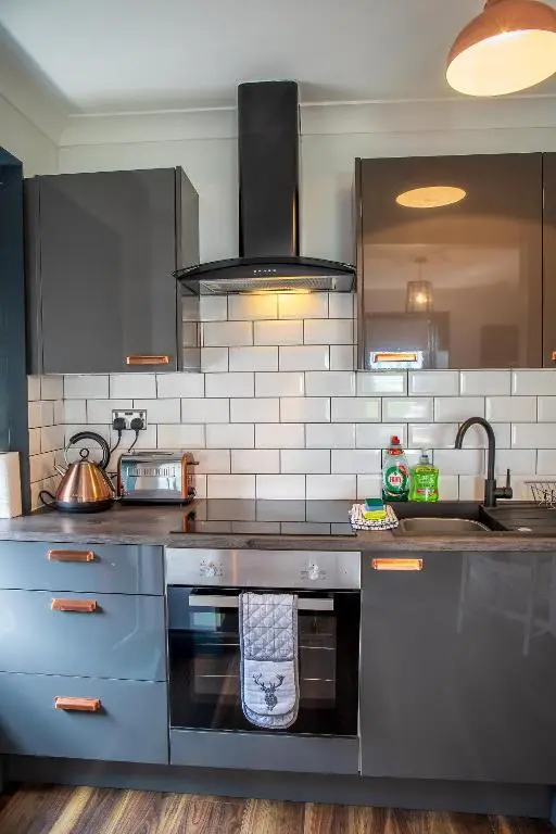 a kitchen with stainless steel appliances and a sink at Caledonian Canal Studio in Inverness