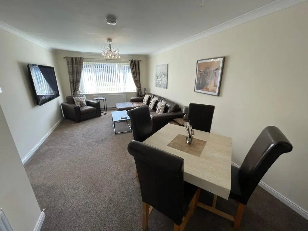 a living room with a table and chairs and a couch at Holm from Home in Inverness