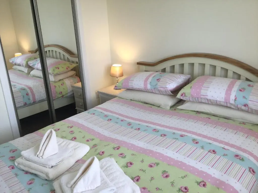 a bedroom with two beds with towels and mirrors at Morning Field Apartment Free Parking in Inverness