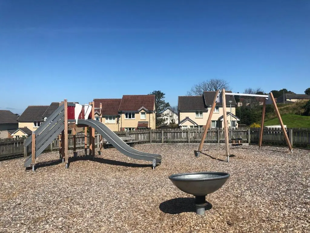 a playground with a slide and a bowl on the ground at Morning Field Apartment Free Parking in Inverness
