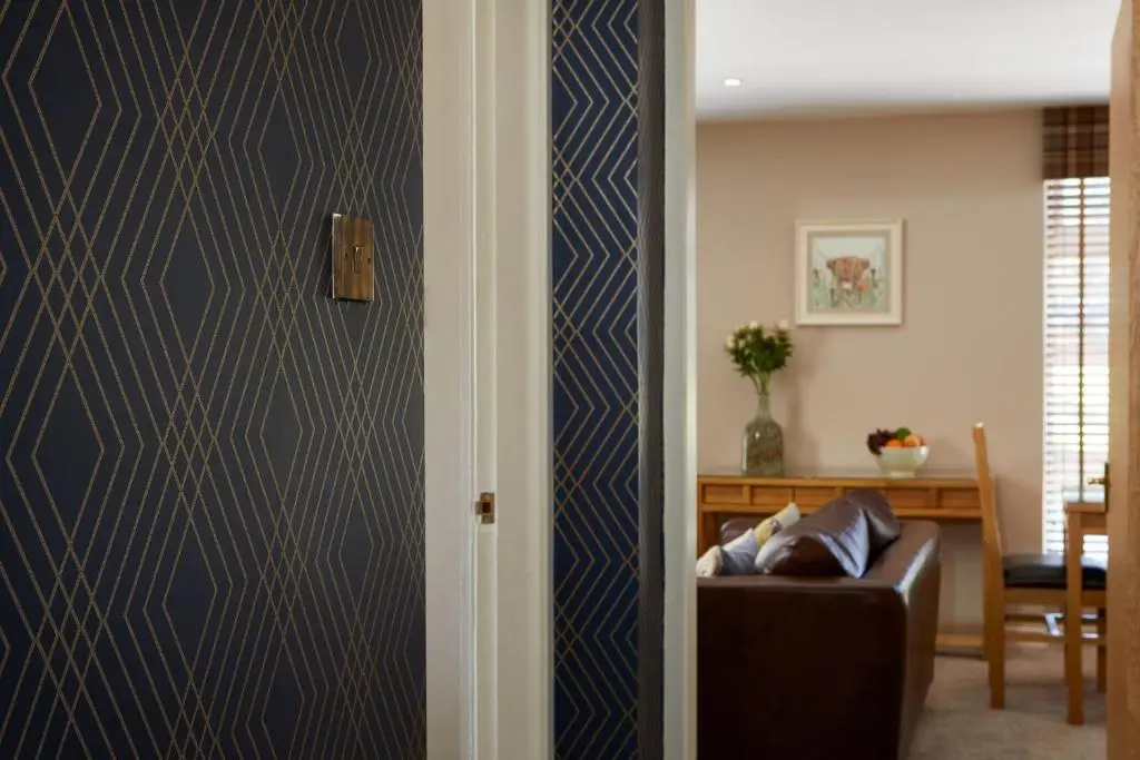 a living room with a blue and white wall at Macdonald Woodland Lodges at Macdonald Aviemore Resort in Aviemore