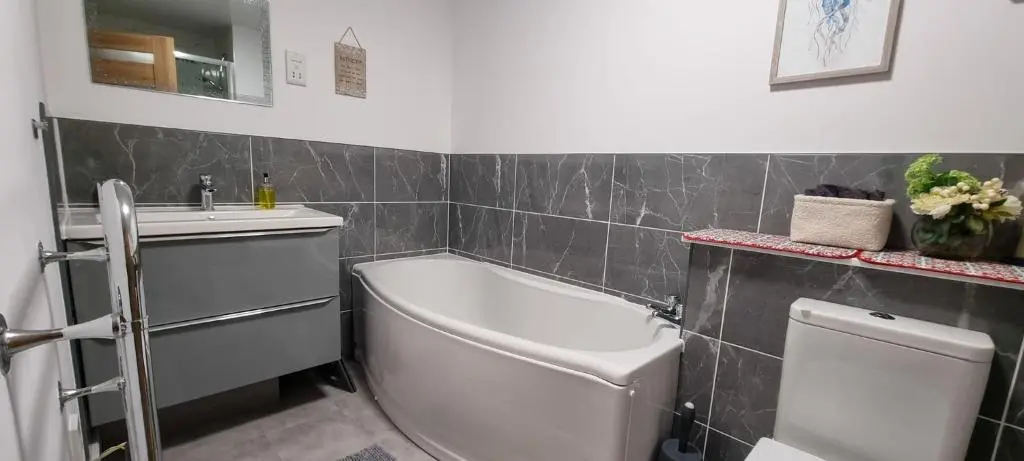 a bathroom with a tub and a sink and a toilet at Heart of Inverness-city apartment in Inverness