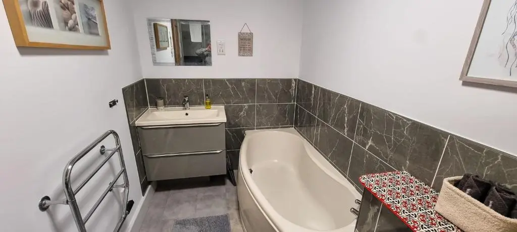 a bathroom with a tub and a sink and a bath tub at Heart of Inverness-city apartment in Inverness