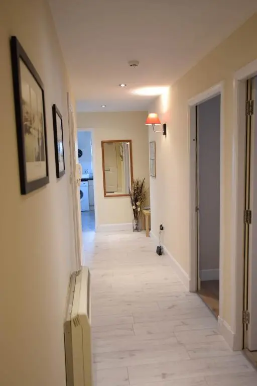 a hallway with a tile floor in a house at Heart of Inverness-city apartment in Inverness