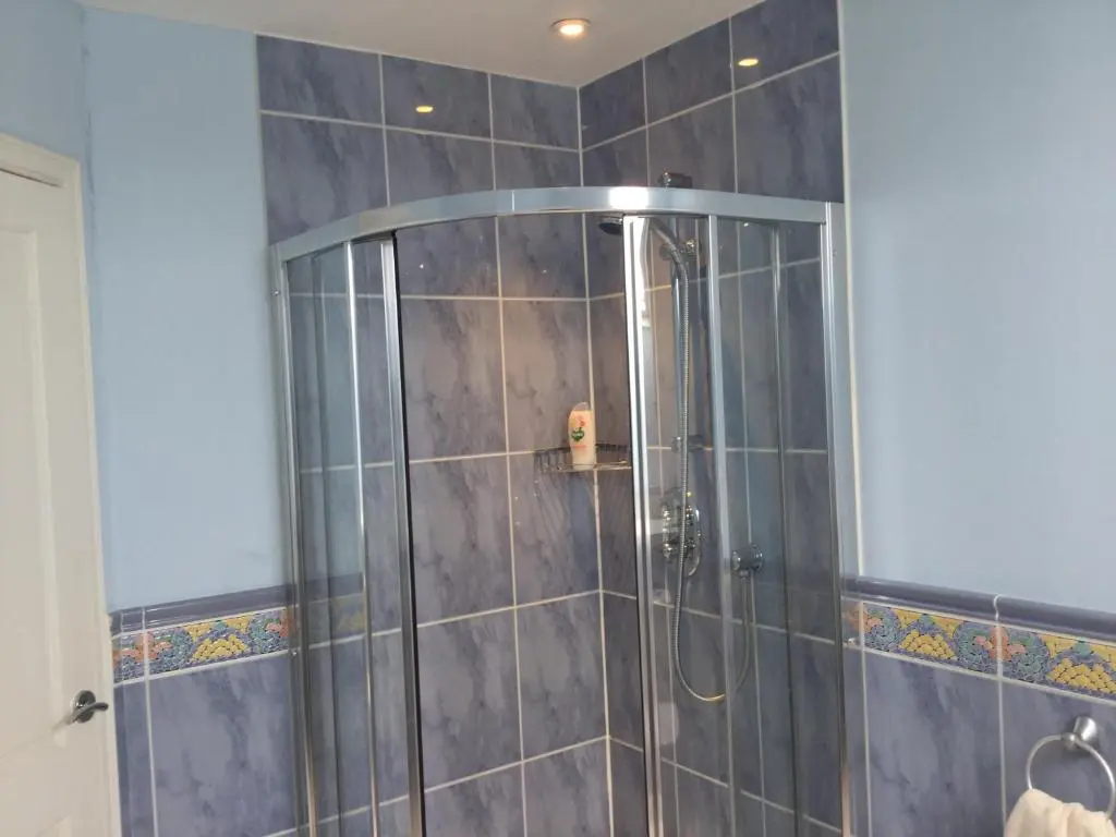 a shower with a glass door in a bathroom at West Heather House Free Parking in Inverness