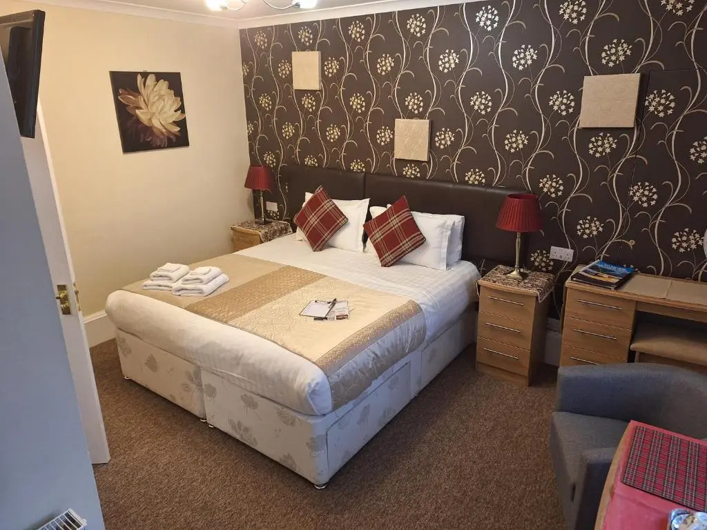 a hotel room with a bed and a chair at Torridon Guest House in Inverness