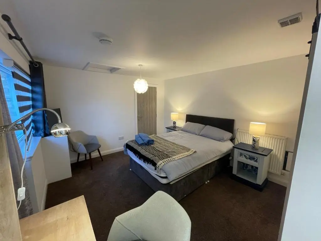 a bedroom with a bed and a desk and a chair at Serviced Accommodation Moray in Elgin