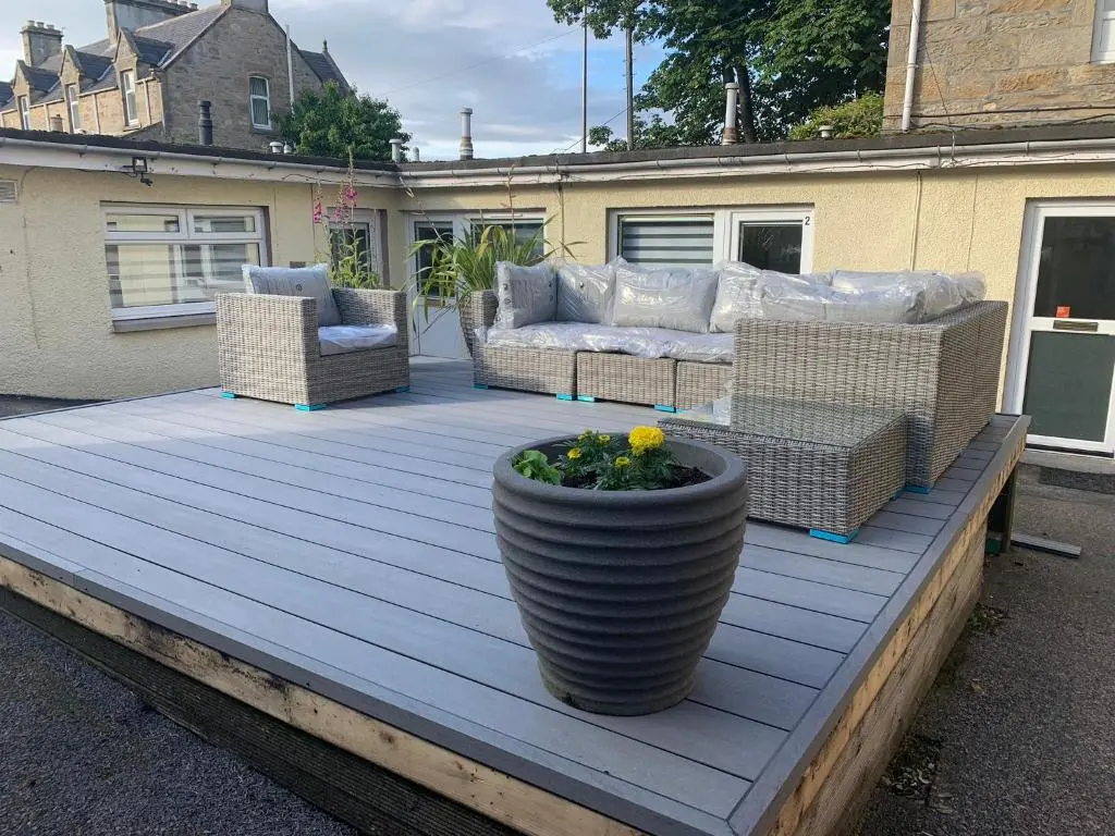 a patio with couches and a flower pot on a deck at Serviced Accommodation Moray in Elgin