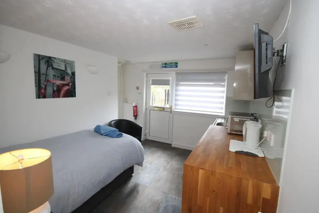 a bedroom with a bed and a desk and a television at Serviced Accommodation Moray in Elgin