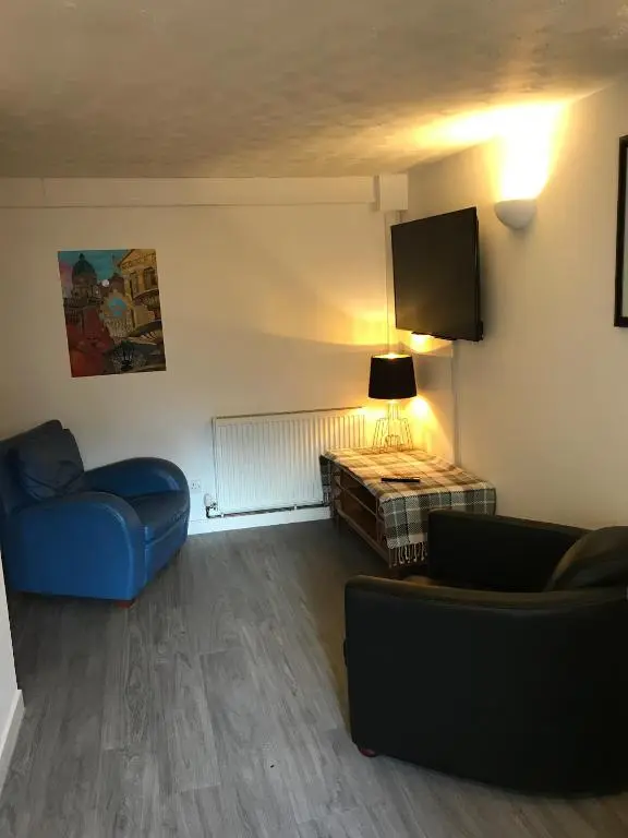 a living room with a blue couch and a table at Serviced Accommodation Moray in Elgin
