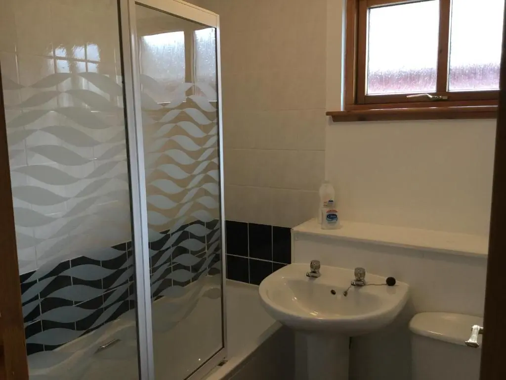 a bathroom with a shower and a sink at Culloden Apartment Free Parking in Inverness