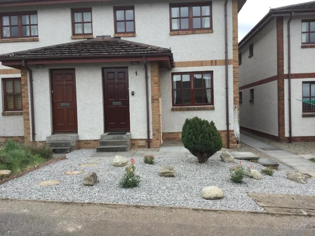 a house with a bunch of rocks in front of it at Culloden Apartment Free Parking in Inverness