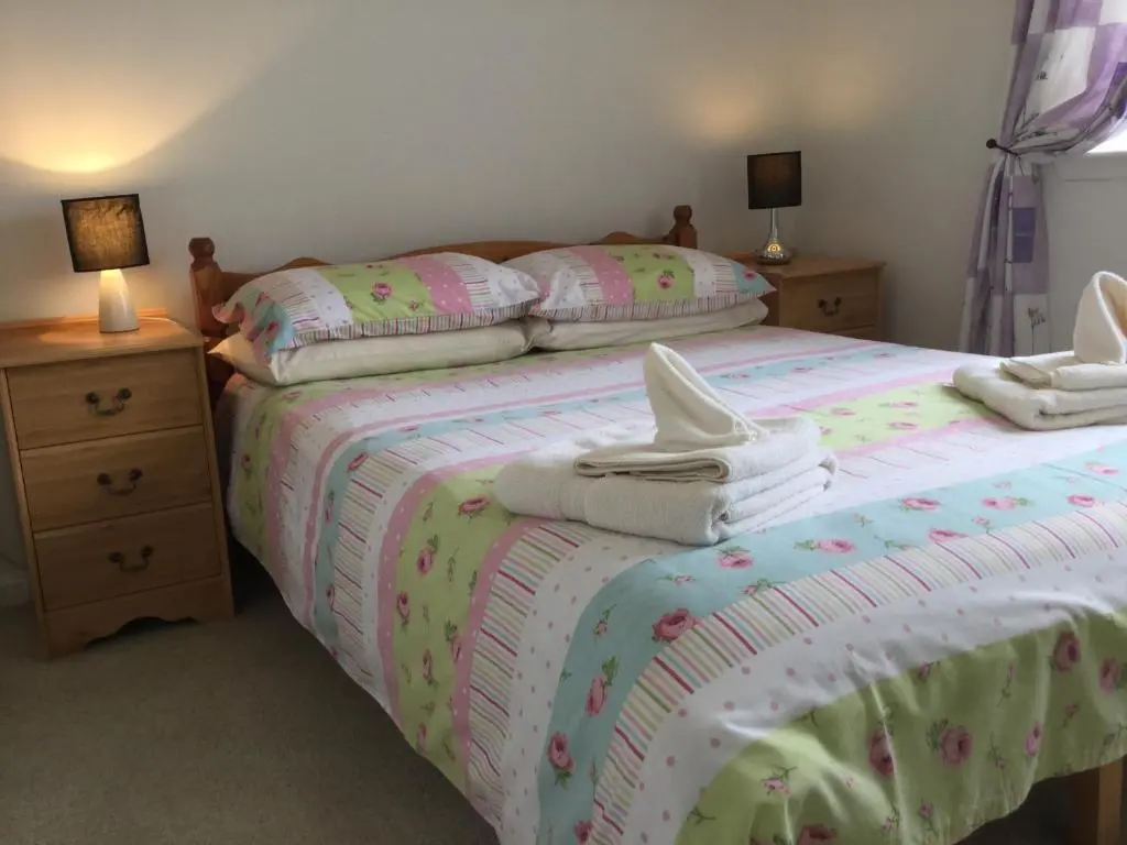 a bedroom with two beds with towels on them at Castle Heather House Free Parking in Inverness