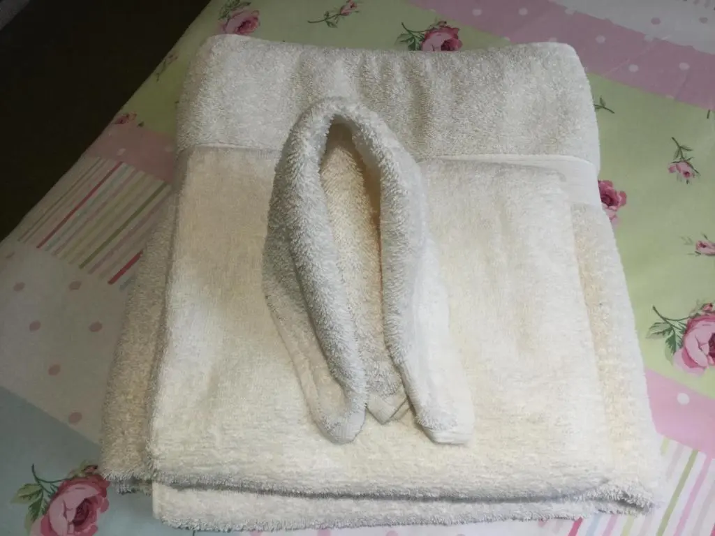 a white towel sitting on top of a bed at Castle Heather House Free Parking in Inverness