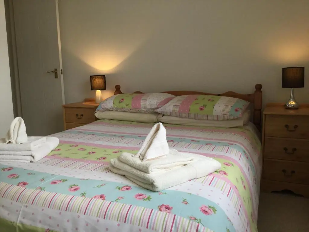two beds with towels on them in a bedroom at Castle Heather House Free Parking in Inverness