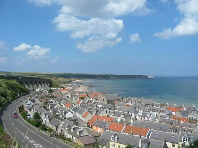 a town with houses and a road next to the ocean at The Royal Oak Hotel in Cullen