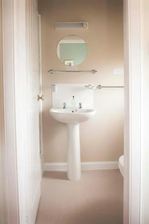 a bathroom with a sink and a mirror at The Royal Oak Hotel in Cullen