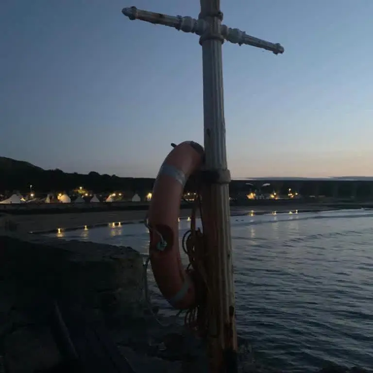 a pole with a street light next to a body of water at The Royal Oak Hotel in Cullen