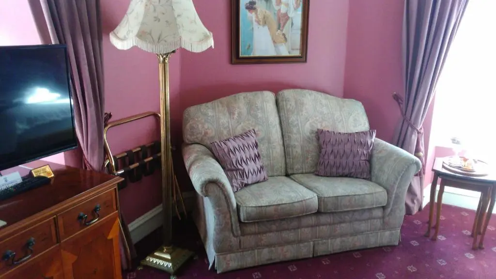 a living room with a chair and a lamp at Disblair House in Newmachar
