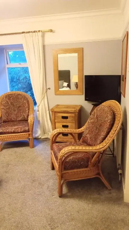 a living room with a chair and a television at Disblair House in Newmachar