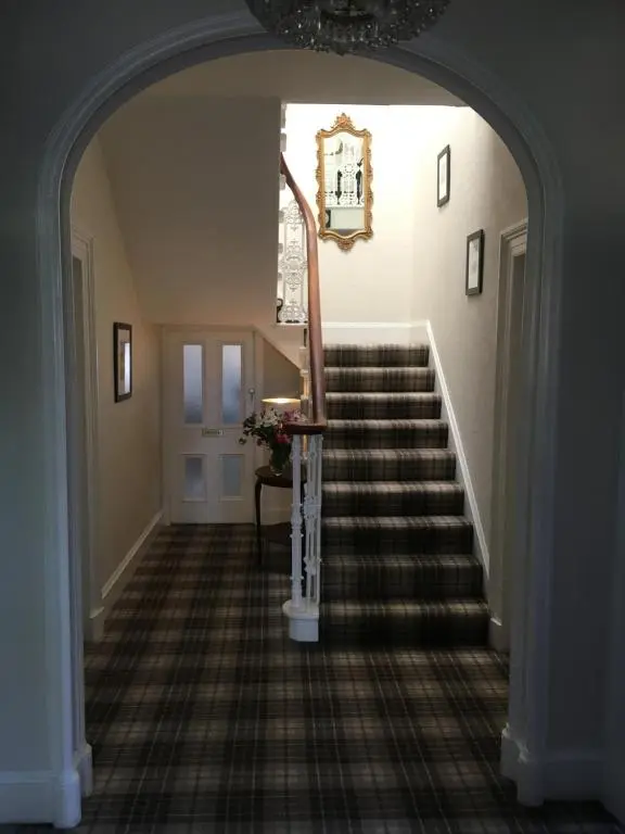 an arched hallway with a staircase in a house at Ballifeary House in Inverness