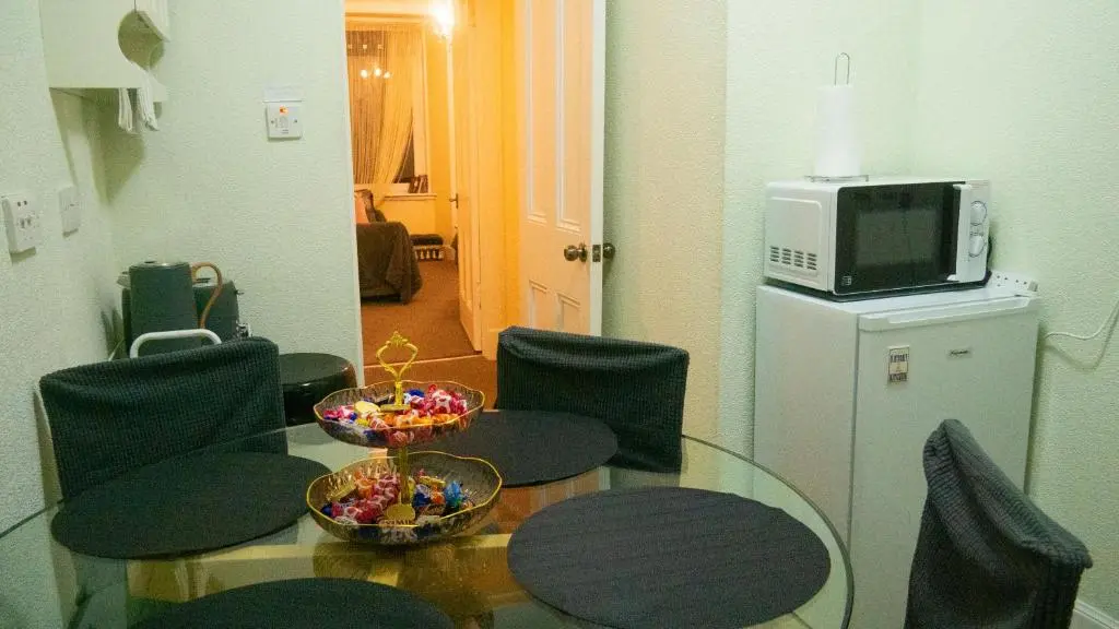 a room with a table and chairs and a microwave at Cozy Central Apartment in Inverness