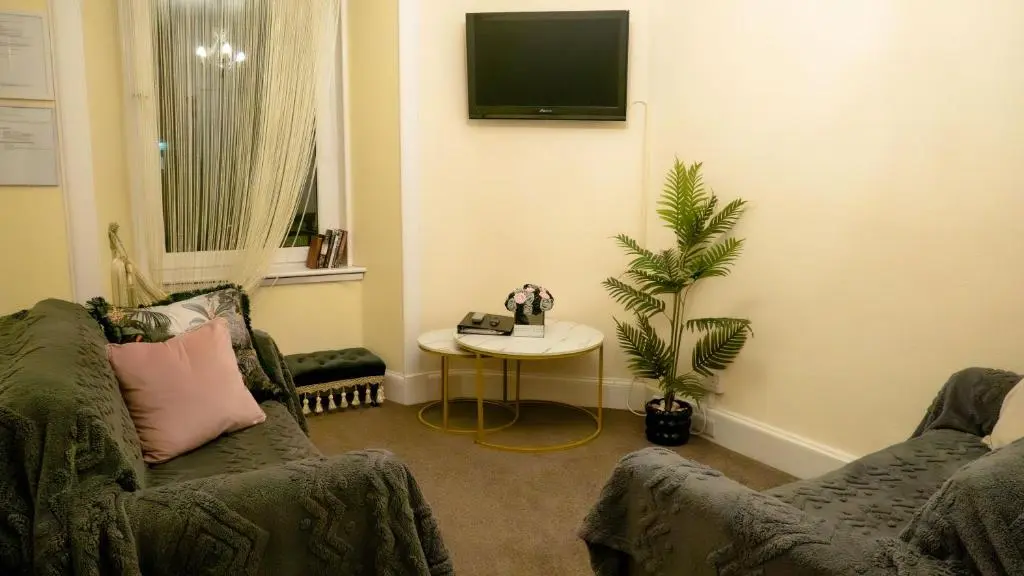 a living room with a couch and a table at Cozy Central Apartment in Inverness
