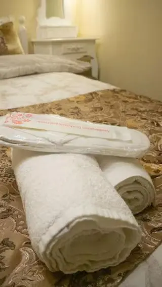 two white towels sitting on top of two beds at Cozy Central Apartment in Inverness
