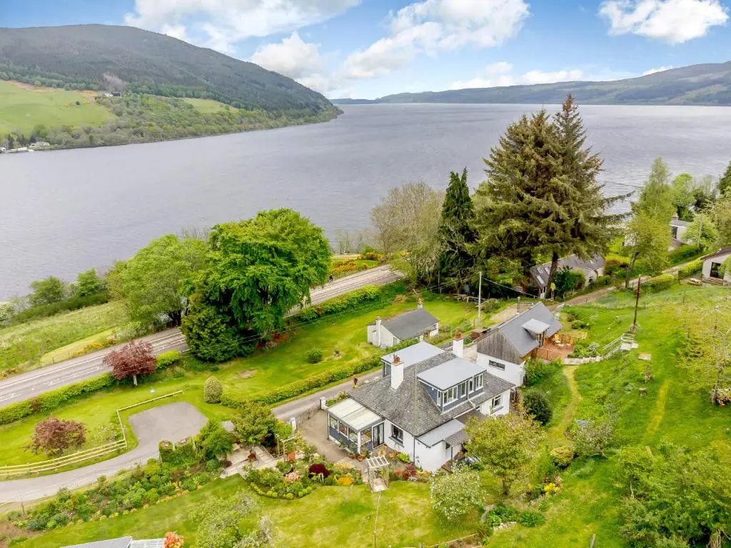 an aerial view of a large house with a lake at Urquhart Bay B&B in Drumnadrochit