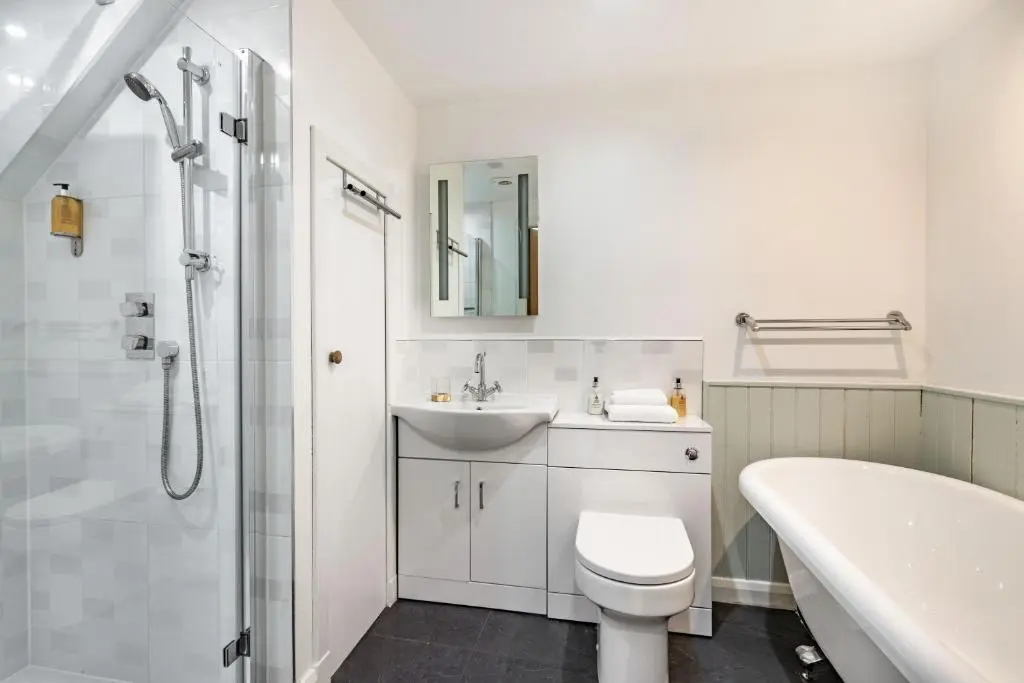 a bathroom with a sink and a toilet and a tub at Urquhart Bay Croft in Drumnadrochit