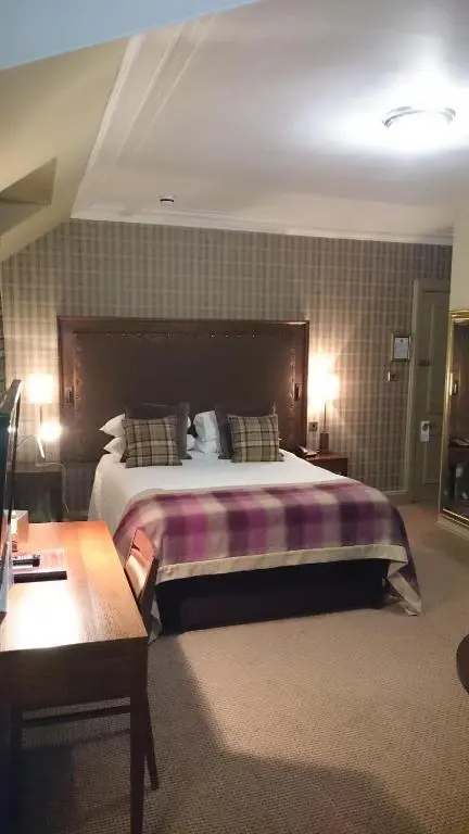 a bedroom with a large bed in a room at Cairngorm Hotel in Aviemore