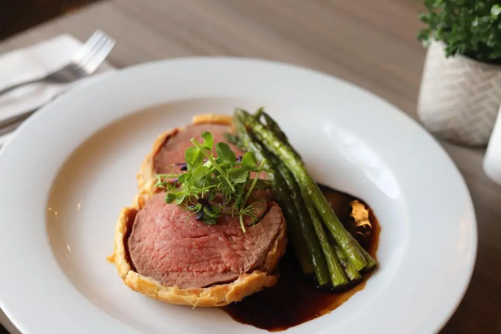 a plate with a piece of meat and asparagus at Ardennan House Hotel in Inverurie