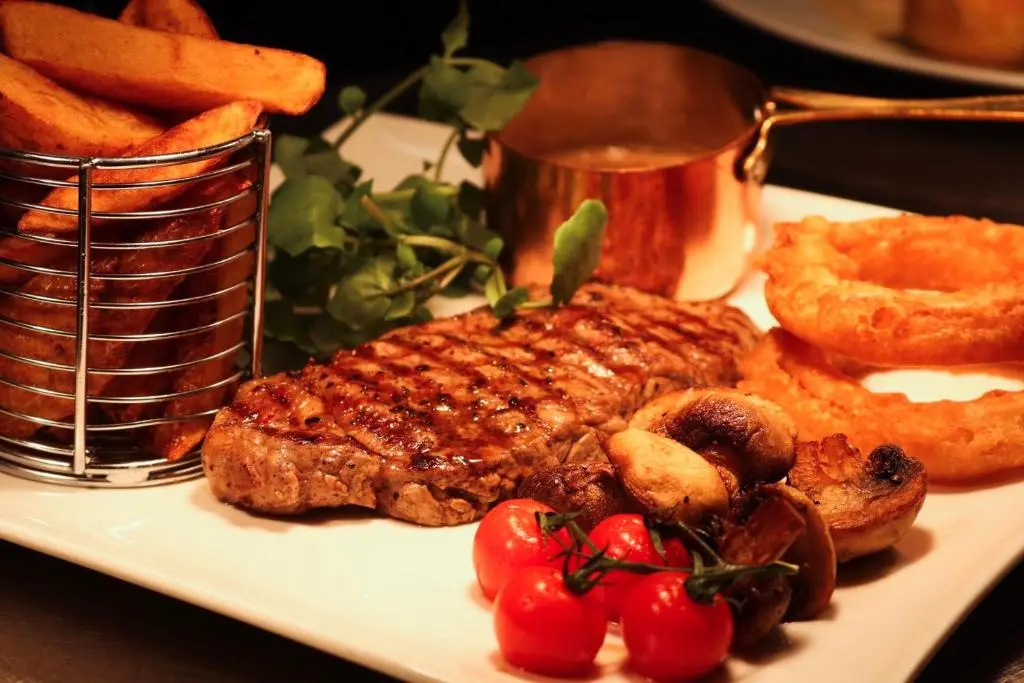 a plate of food with steak and pretzels and tomatoes at Ardennan House Hotel in Inverurie