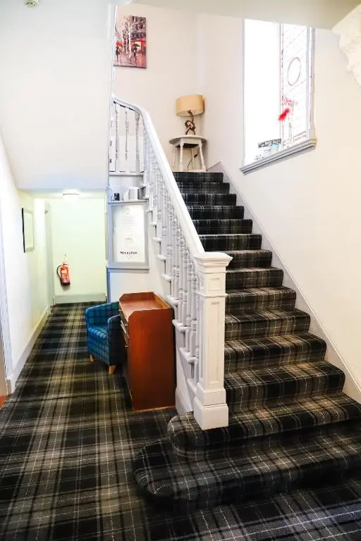 a staircase in a house with a stair case at Ardennan House Hotel in Inverurie