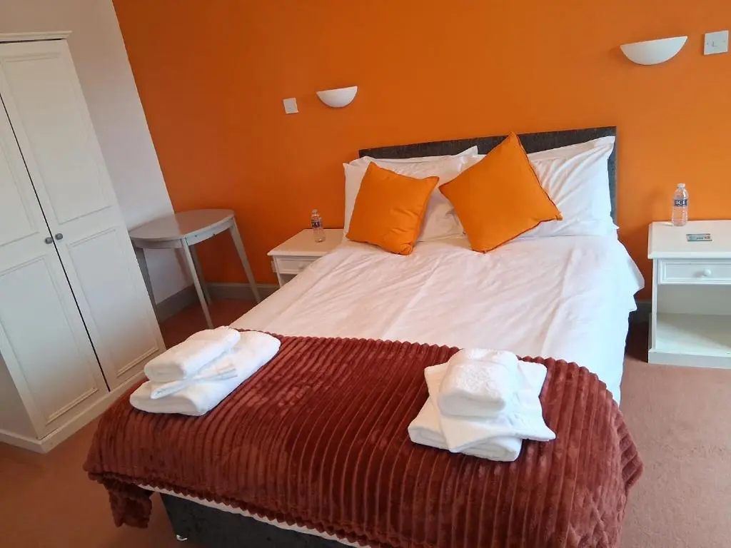 a bedroom with a bed with towels on it at Hotel Square in Tomintoul