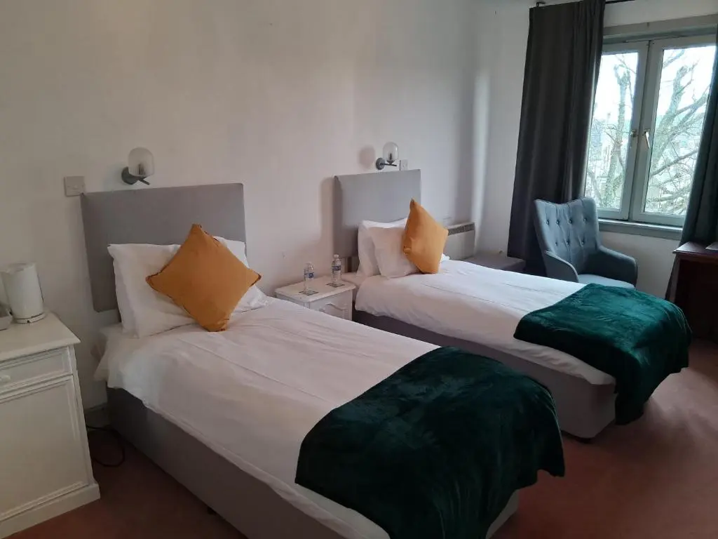a hotel room with two beds and a window at Hotel Square in Tomintoul