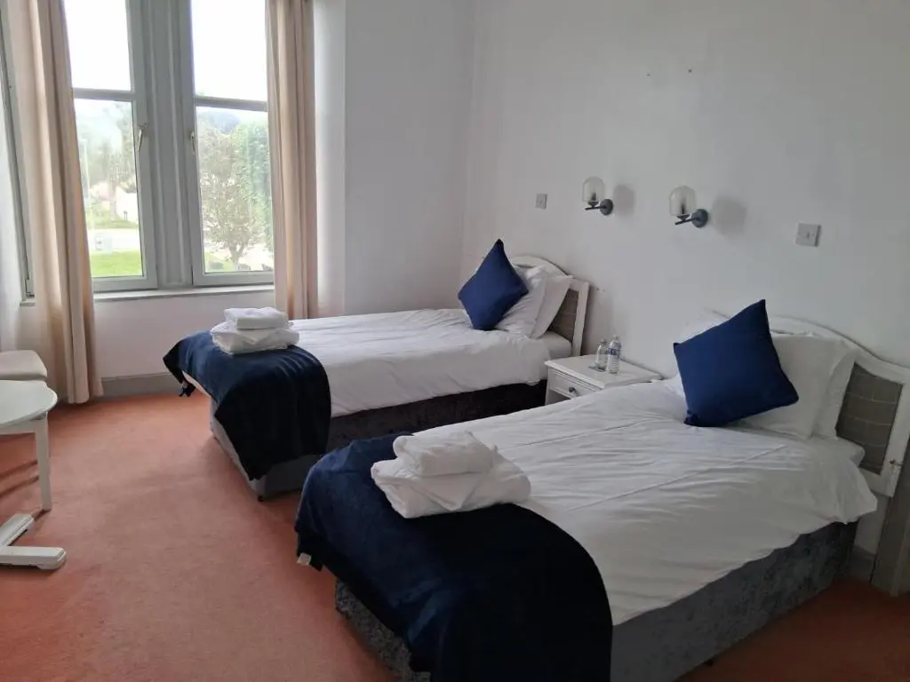 a hotel room with two beds and a window at Hotel Square in Tomintoul