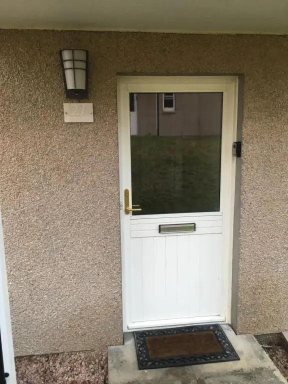 a white door of a house with a window at Inchmarlo villa27 in Banchory