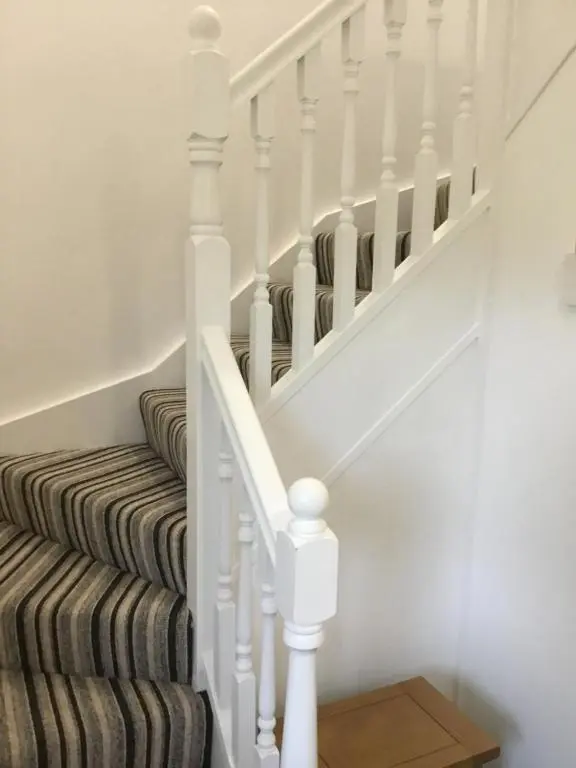 a staircase with white railings and a striped stair case at Inchmarlo villa27 in Banchory