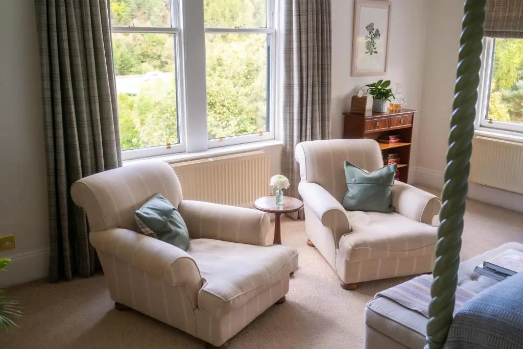 a living room with two chairs and a couch at Craigellachie Hotel of Speyside in Craigellachie