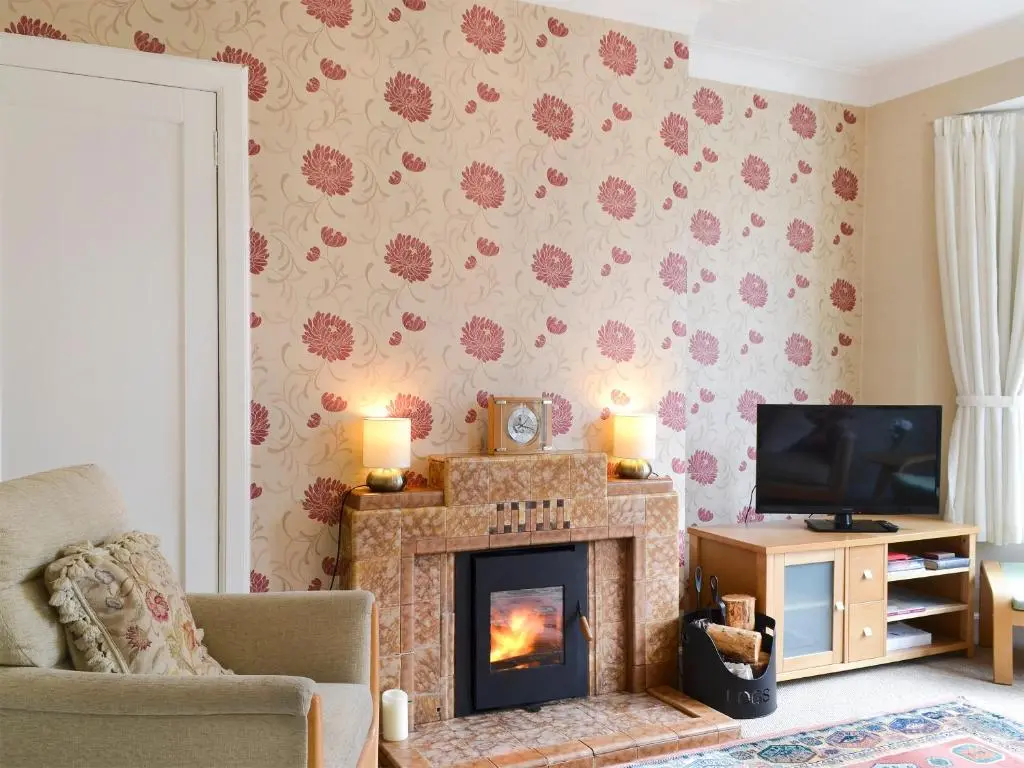 a living room with a fireplace and a tv at Viewhill Villa in Inverness