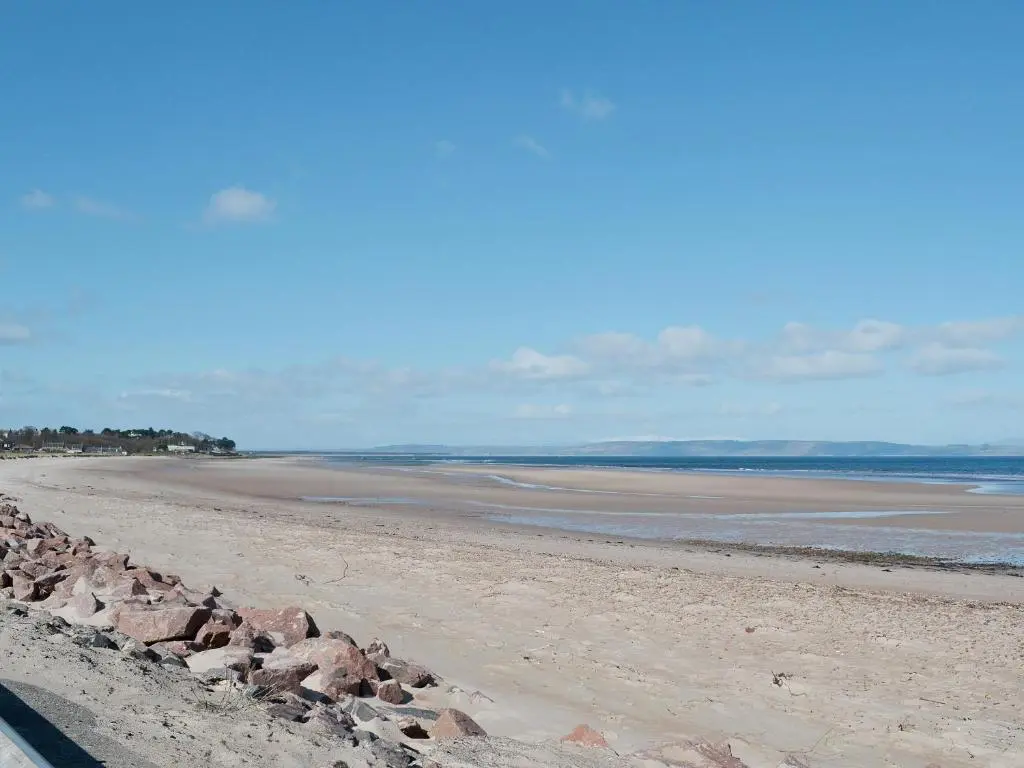 a beach with rocks on the sand and water at Viewhill Villa in Inverness