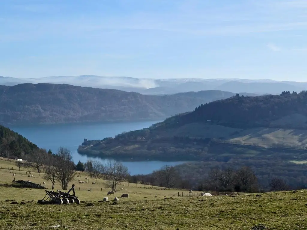 a person standing on a hill with a view of a lake at Riverside Cottage in Drumnadrochit