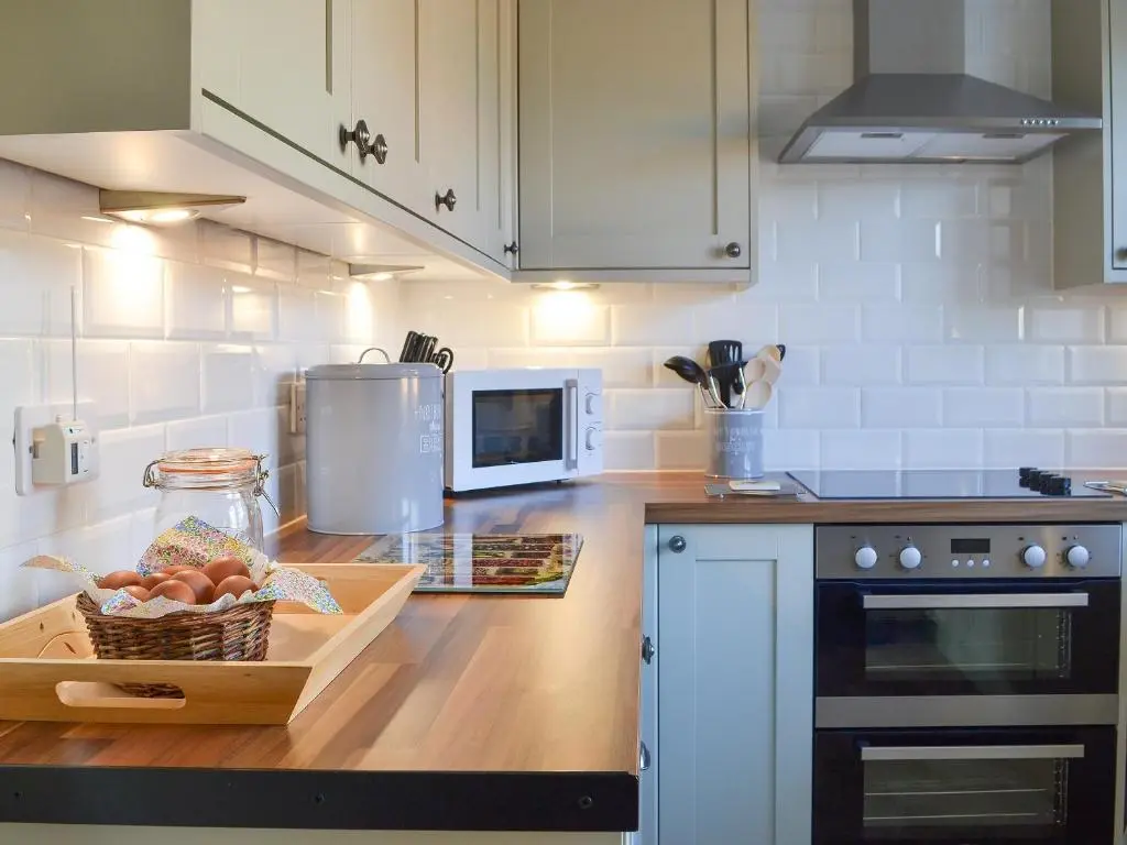 a kitchen with a counter with a basket of fruit at Glebe Cottage in Urray